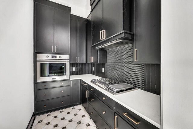 kitchen featuring appliances with stainless steel finishes, wall chimney exhaust hood, and decorative backsplash