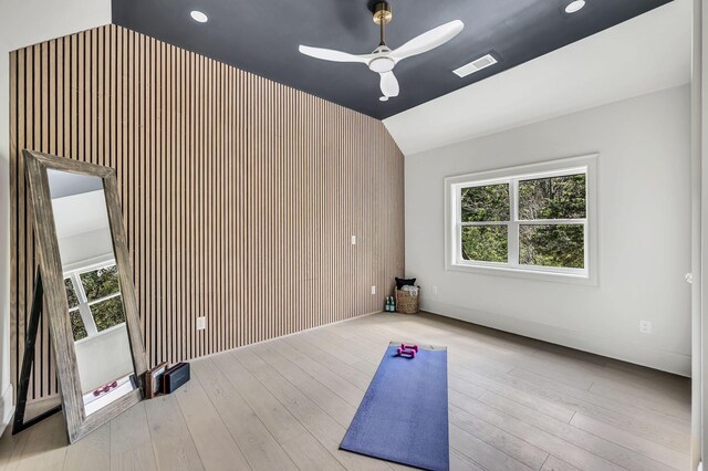 workout area featuring lofted ceiling, light hardwood / wood-style floors, ceiling fan, and plenty of natural light