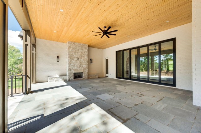 view of patio featuring ceiling fan and an outdoor stone fireplace