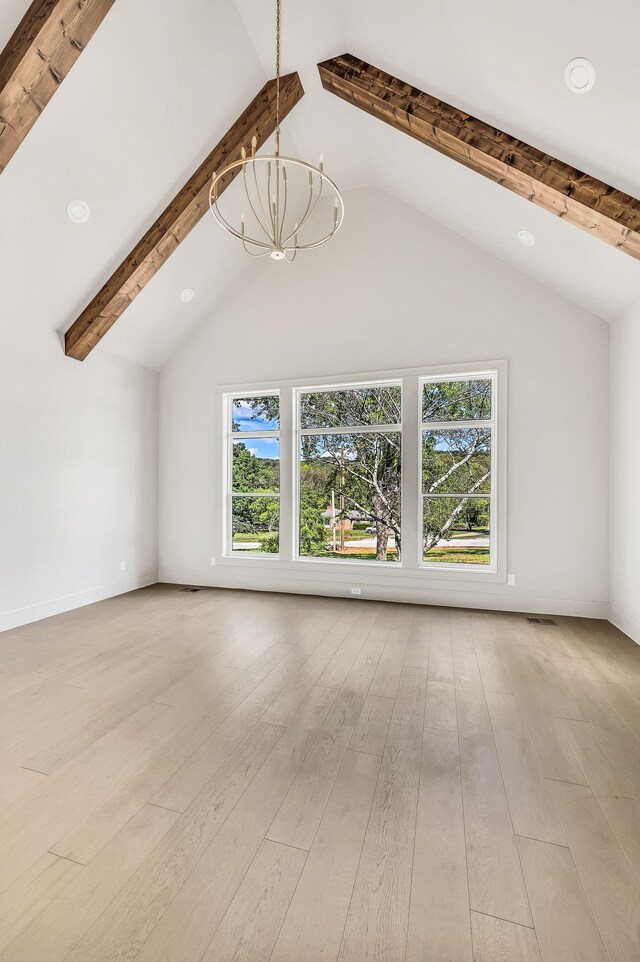 unfurnished living room featuring beamed ceiling, high vaulted ceiling, light wood-type flooring, and an inviting chandelier