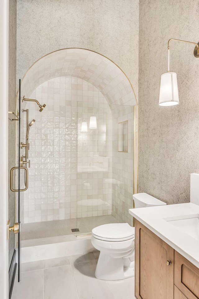 bathroom with tile patterned flooring, vanity, a shower with shower door, and toilet