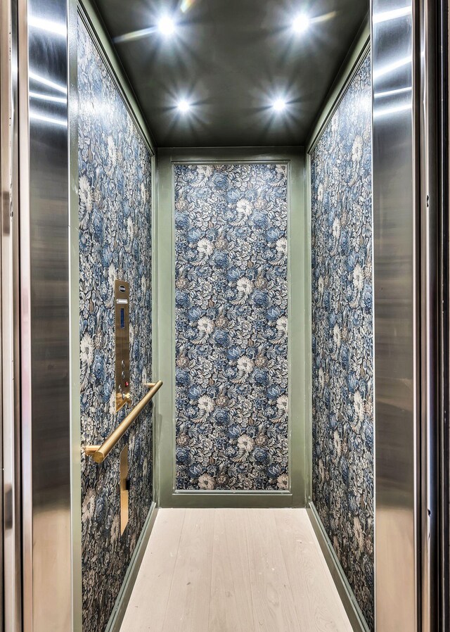 bathroom featuring hardwood / wood-style flooring and elevator