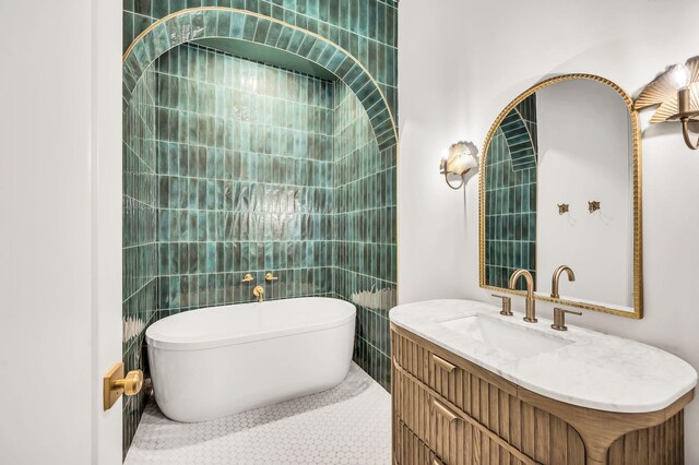 bathroom with vanity, tile patterned flooring, tile walls, and a tub