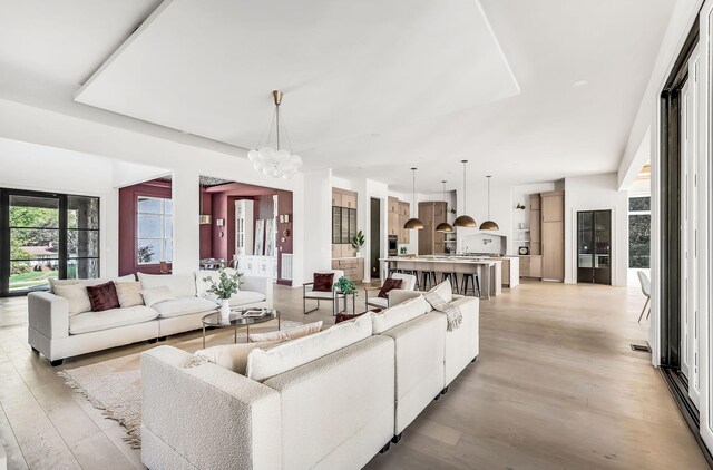 living room featuring a chandelier and light hardwood / wood-style floors