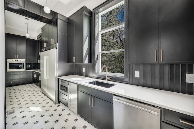 kitchen featuring appliances with stainless steel finishes, decorative light fixtures, and sink