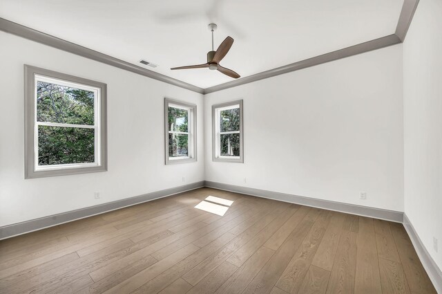 unfurnished room with ornamental molding, ceiling fan, and light wood-type flooring