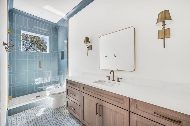 bathroom with tile patterned flooring, vanity, toilet, and a shower with shower door