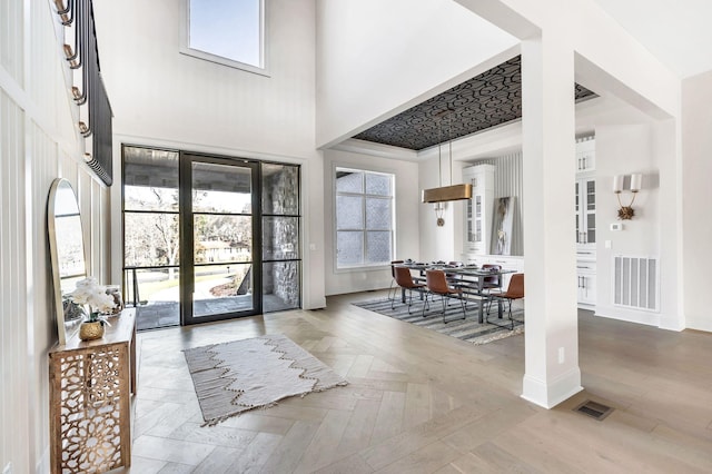 foyer entrance with parquet flooring and a high ceiling