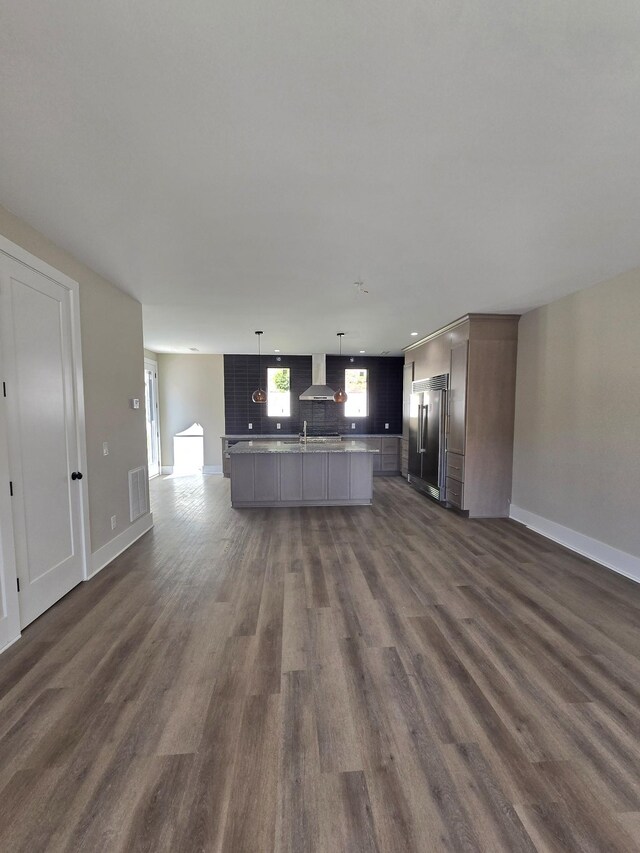 unfurnished living room featuring sink and dark wood-type flooring