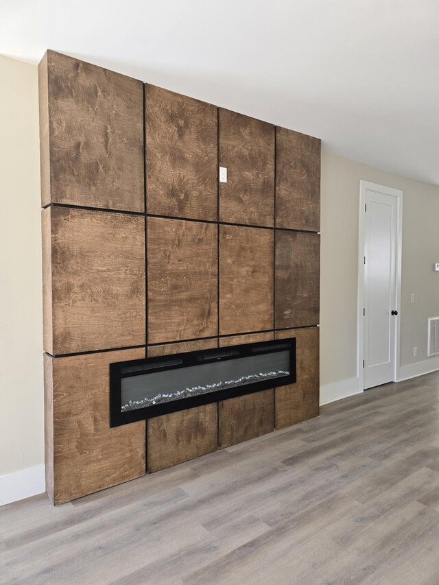 interior details featuring wood-type flooring and a fireplace