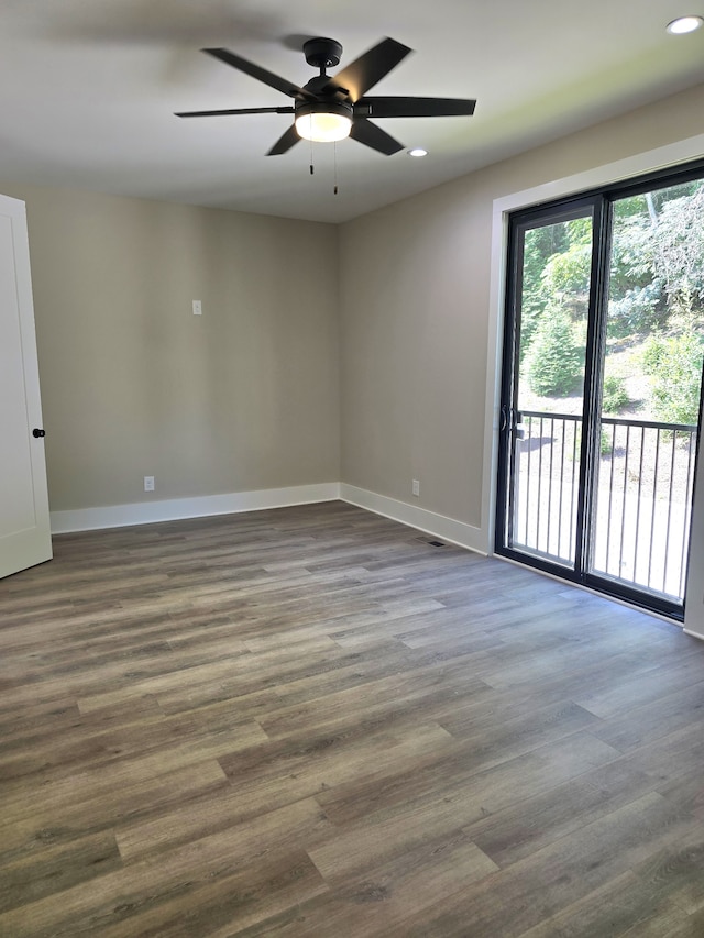 empty room with ceiling fan and dark hardwood / wood-style flooring