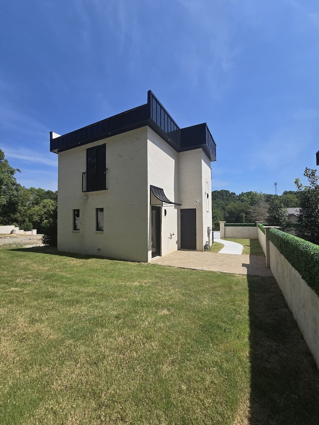 rear view of house featuring a patio and a yard