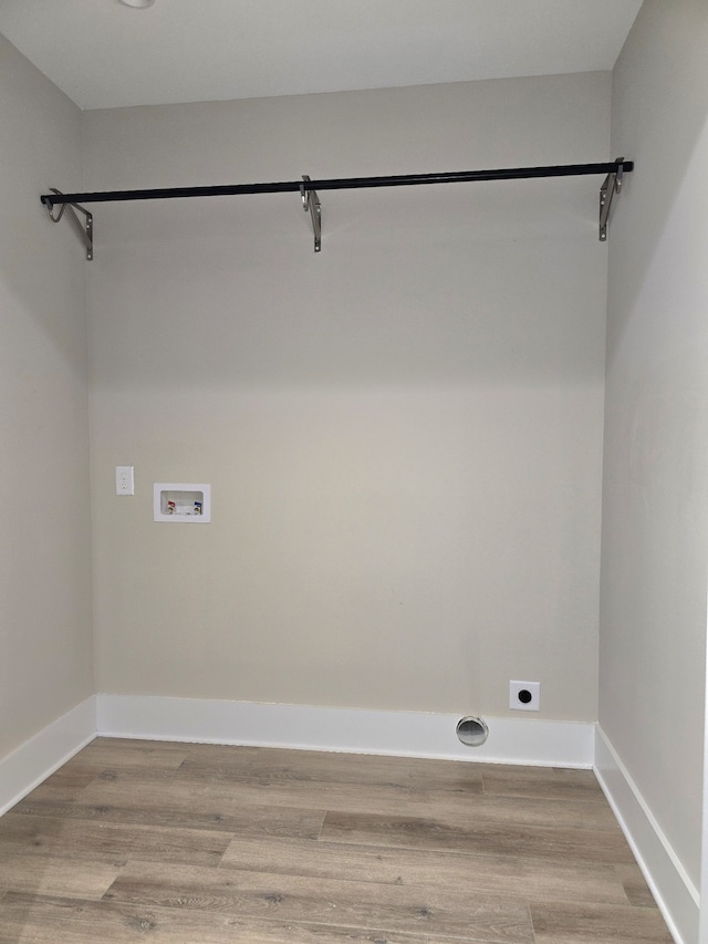 laundry area with hookup for a washing machine, hookup for an electric dryer, and light hardwood / wood-style flooring