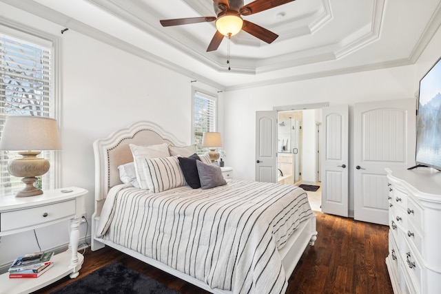 bedroom with ceiling fan, a tray ceiling, crown molding, and dark wood-type flooring