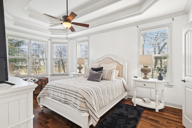 bedroom with ornamental molding, a tray ceiling, ceiling fan, and dark wood-type flooring