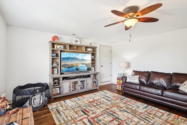 living room featuring ceiling fan and dark hardwood / wood-style floors