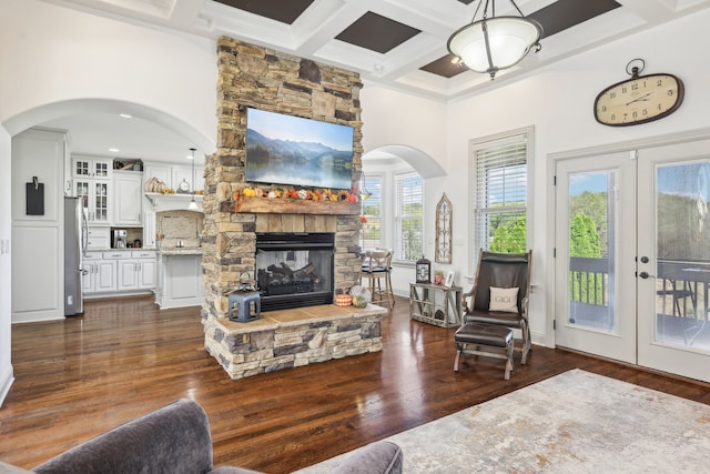 living room featuring coffered ceiling, a fireplace, and dark hardwood / wood-style flooring