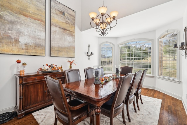 dining room with dark hardwood / wood-style flooring and a notable chandelier