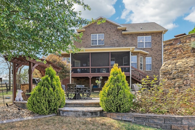 rear view of house with a patio and a sunroom