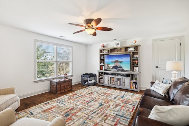 living room with ceiling fan and dark wood-type flooring