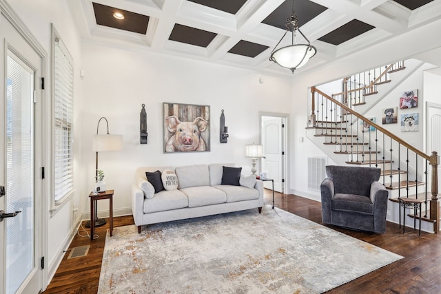 living room featuring coffered ceiling, beamed ceiling, dark hardwood / wood-style floors, and ornamental molding