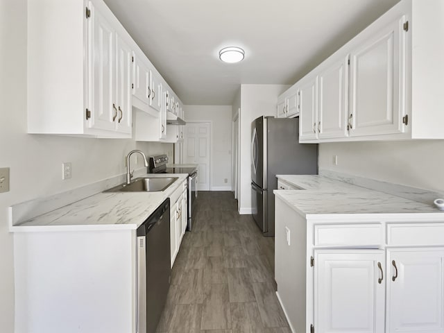 kitchen with hardwood / wood-style flooring, sink, white cabinets, stainless steel appliances, and light stone countertops