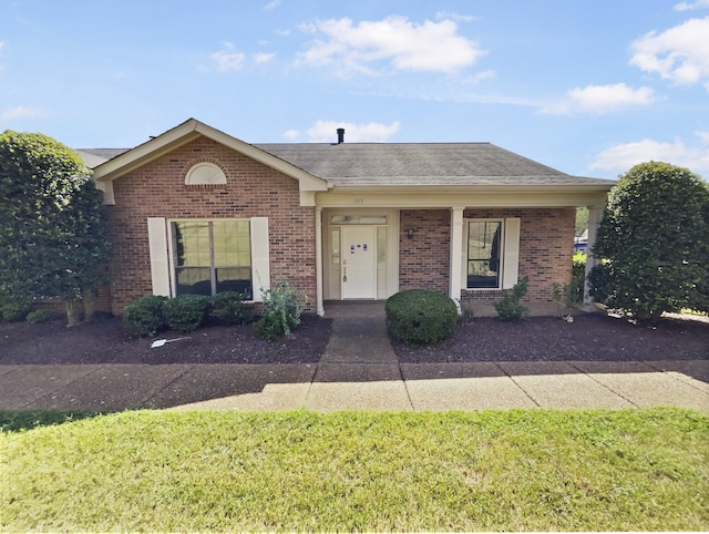 single story home with a front lawn and covered porch