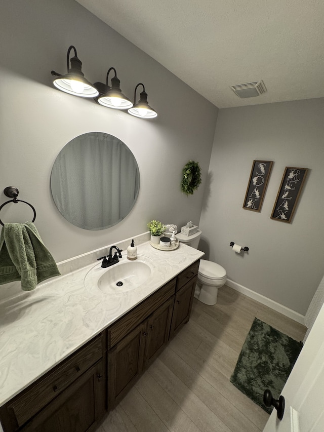 bathroom featuring vanity, hardwood / wood-style floors, and toilet