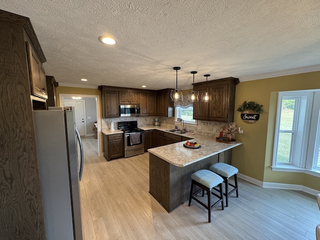 kitchen featuring a wealth of natural light, appliances with stainless steel finishes, and light wood-type flooring