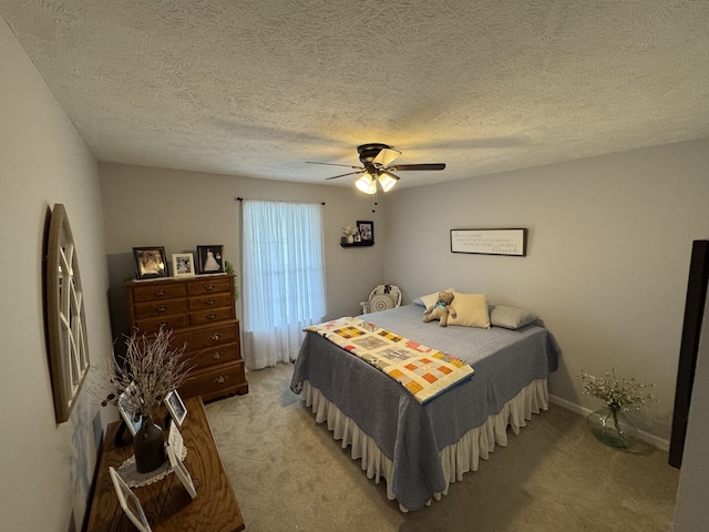 bedroom featuring ceiling fan, light colored carpet, and a textured ceiling