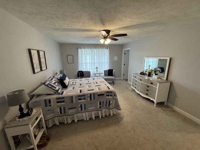 bedroom with ceiling fan, carpet flooring, and a textured ceiling