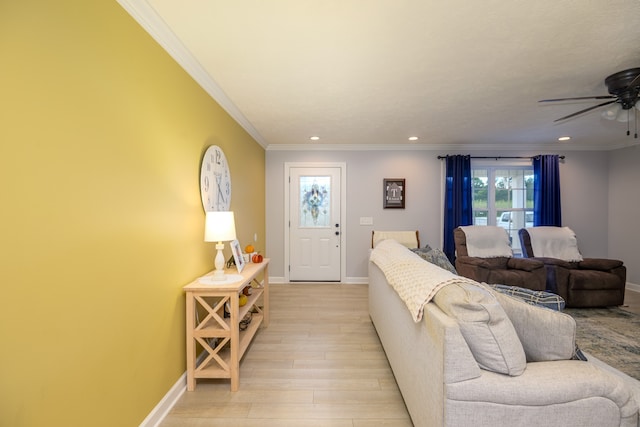 living room with light wood-type flooring, crown molding, and ceiling fan