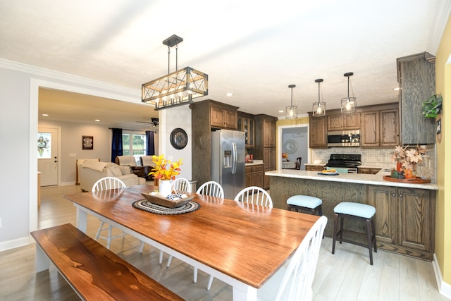 dining area featuring light wood-type flooring and ornamental molding