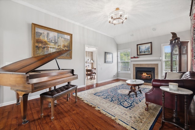 living room featuring lofted ceiling, ornamental molding, a chandelier, a fireplace, and dark hardwood / wood-style flooring