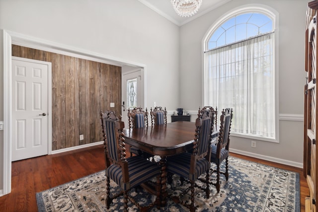 dining room with an inviting chandelier, ornamental molding, and dark hardwood / wood-style flooring