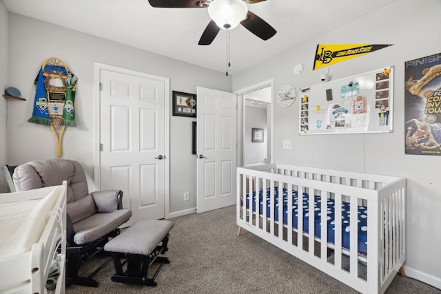 bedroom with ceiling fan, a nursery area, and carpet flooring