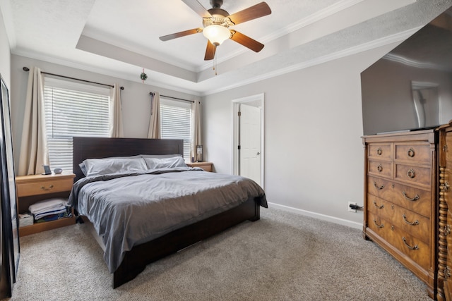 carpeted bedroom featuring ornamental molding, a tray ceiling, and ceiling fan