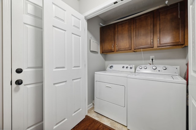 laundry room with cabinets, independent washer and dryer, and dark wood-type flooring