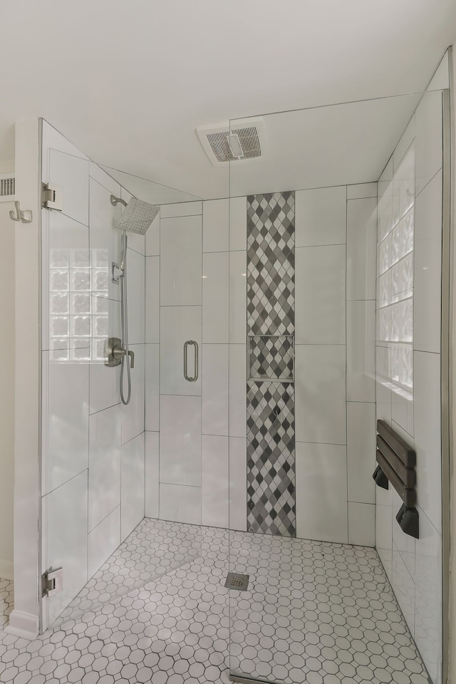 bathroom with a shower with door and tile patterned flooring