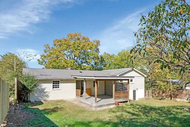 rear view of property with a patio and a lawn