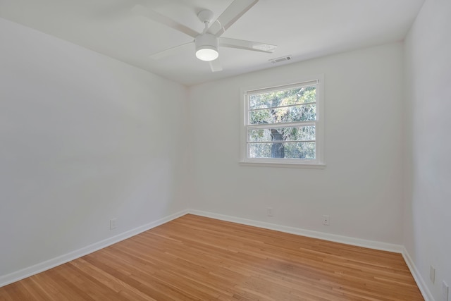 empty room with ceiling fan and light hardwood / wood-style flooring