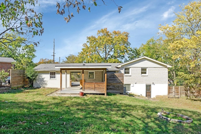 rear view of house featuring a wooden deck and a yard