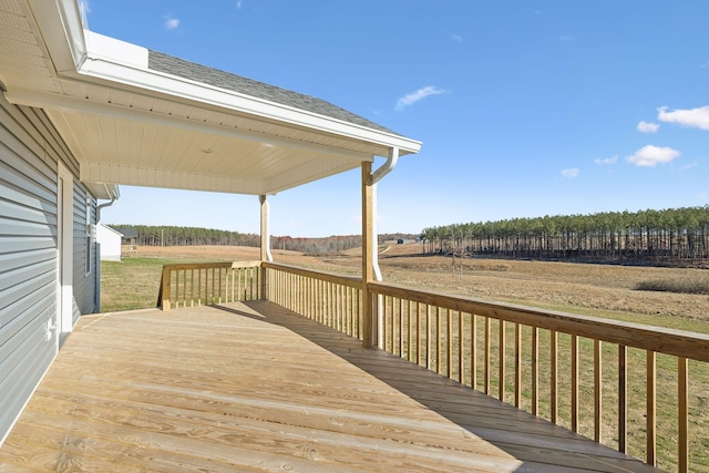 wooden deck featuring a yard and a rural view