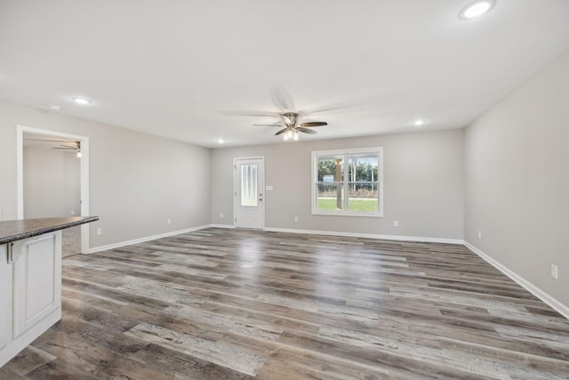 unfurnished living room featuring ceiling fan and wood-type flooring