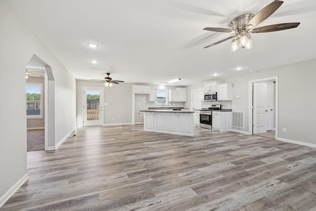 kitchen featuring white cabinets, appliances with stainless steel finishes, light wood-type flooring, and ceiling fan