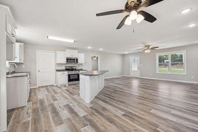 kitchen featuring appliances with stainless steel finishes, ceiling fan, sink, light hardwood / wood-style floors, and white cabinetry