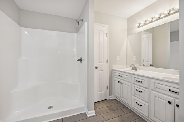 bathroom featuring a shower, vanity, and tile patterned flooring