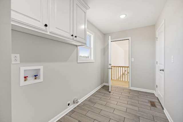 clothes washing area with light hardwood / wood-style floors, cabinets, and washer hookup