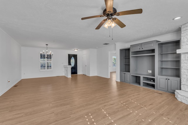 unfurnished living room featuring crown molding, a fireplace, a textured ceiling, light hardwood / wood-style floors, and ceiling fan with notable chandelier