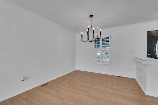 unfurnished dining area featuring an inviting chandelier, light hardwood / wood-style flooring, and crown molding